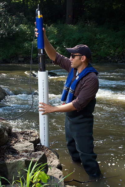 YSI EXO Sonde Being Lowered into a Tube in a Stream